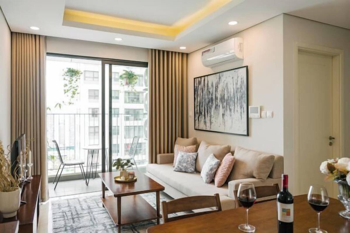 A modern living room with a sofa, a dining table, and a large window.
