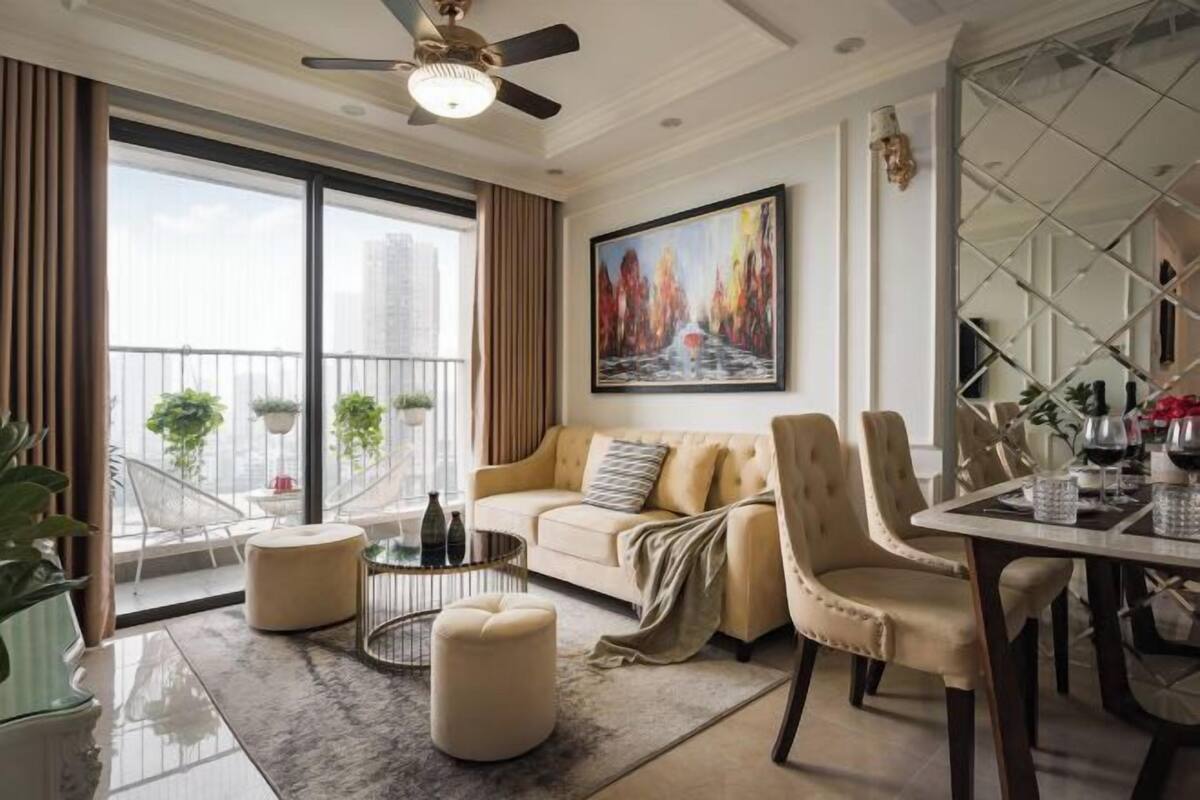 A modern living room with a sofa, ottoman, dining table, and chairs.