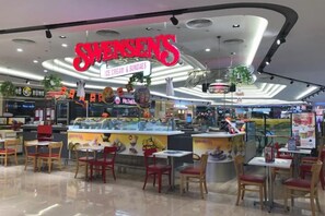 A food court with a prominent ice cream and sundae stand named 'Swensens.' - Vinhomes D'Capitale - HANOIHOMES (Hanoi)