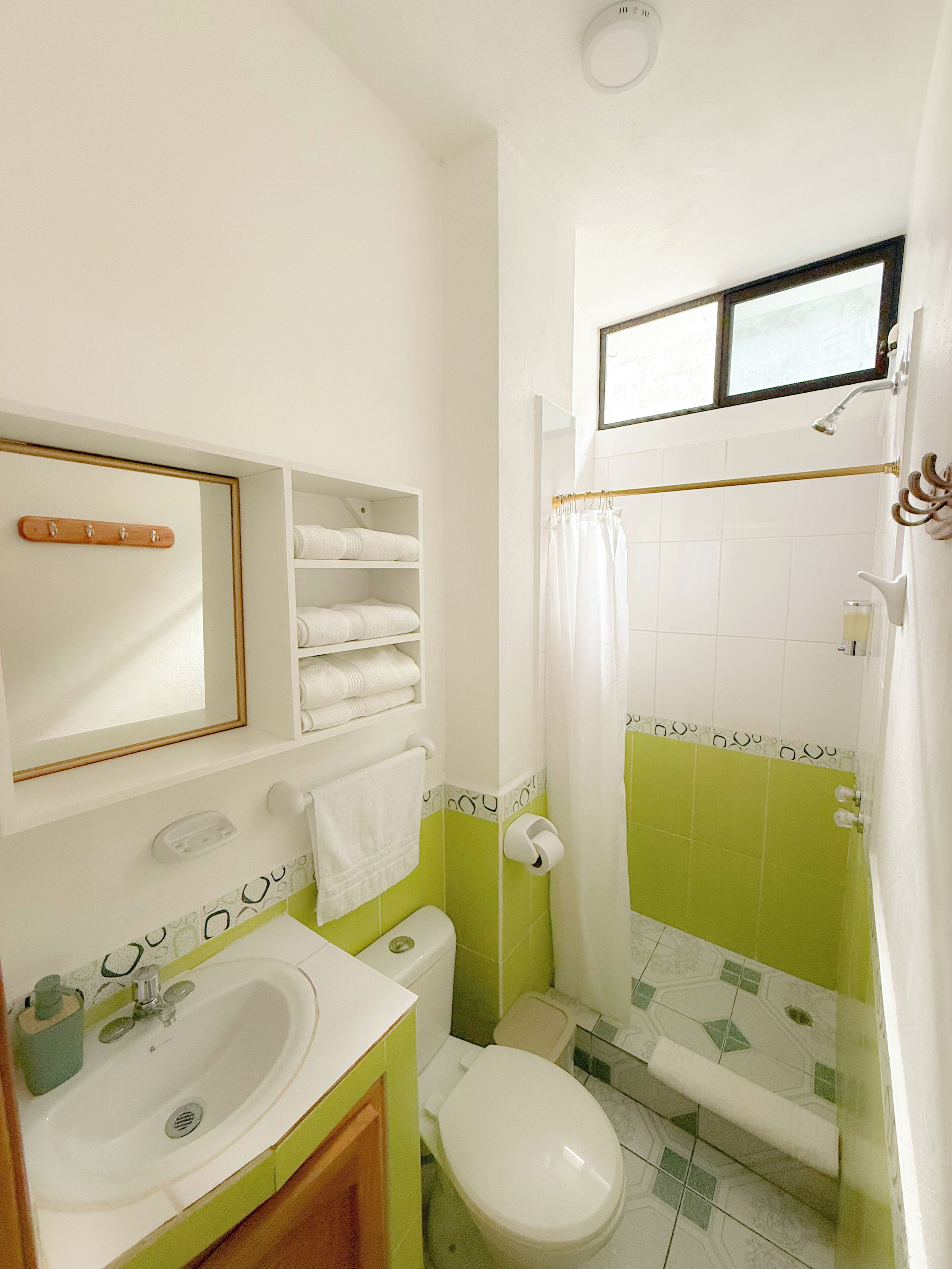 A bathroom with a sink, toilet, and shower area.