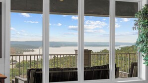 Uma varanda com vista para um rio e montanhas.