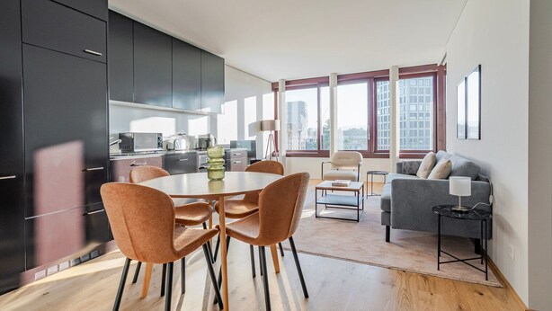 Un apartamento moderno con comedor, sofá y vistas a la ciudad.