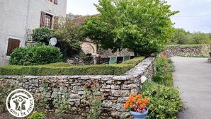 Eine Steinmauer mit einem Blumentopf und einem Logo.