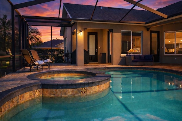 Relax by the private pool and spa area at sunset in this modern outdoor space.
