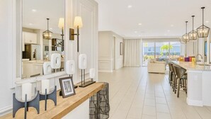 A modern kitchen with a large island, bar stools, and a view of the outdoor area. - “Spacious 10BR Villa w/ Pool, Theater & Themed Kids’ Rooms – Near Disney” (Kissimmee)