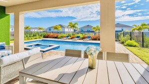 A covered patio area with a pool, lounge chairs, and a table. - “Spacious 10BR Villa w/ Pool, Theater & Themed Kids’ Rooms – Near Disney” (Kissimmee)