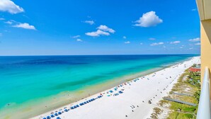 A beach with a clear blue sky, turquoise water, and a white sandy shore. - BeachFront-5 Pools, Starbucks, Movies at Majestic Beach Resort (Panama City Beach)