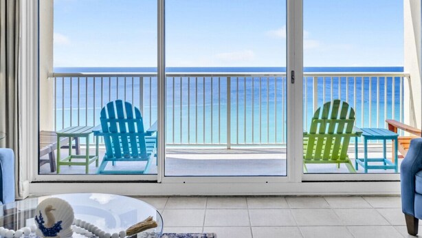 A balcony with a view of the ocean, featuring two green Adirondack chairs and a blue chair. - BeachFront-5 Pools, Starbucks, Movies at Majestic Beach Resort (Panama City Beach)