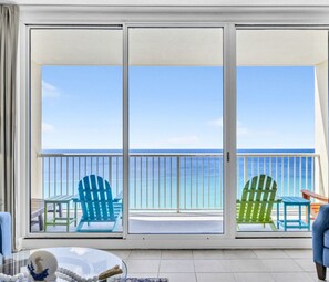 A balcony with a view of the ocean, featuring two green Adirondack chairs and a blue chair. - BeachFront-5 Pools, Starbucks, Movies at Majestic Beach Resort (Panama City Beach)