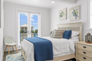 A bedroom with a bed, a chair, a nightstand, and artwork on the wall. - 🌅 Chasing Sunsets | Harbor + Gulf Views | FREE Parasailing ☀️ (Destin)