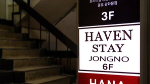 Une enseigne indiquant « Haven Stay » et « Jongno 6F », ce qui signale l’emplacement d’un hôtel.