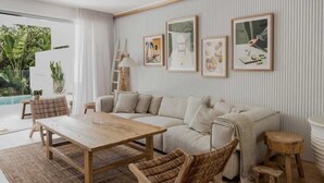 Una sala moderna con un sofá, una mesa de centro y vistas a una piscina.