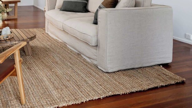 A living room with a sofa, a coffee table, and a rug.