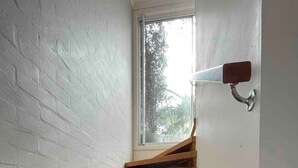 Un escalier en bois avec une fenêtre en haut.