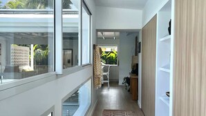 Ein moderner Flur mit großen Fenstern, einem gemusterten Teppich und eingebauten Holzhörnchen.