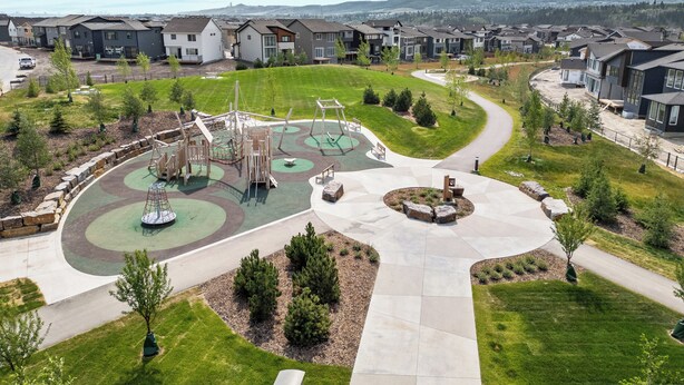 A residential area with modern houses, a playground, and a landscaped park area.