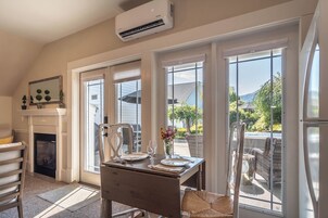 Un comedor con una mesa dispuesta para dos, una chimenea y vistas al exterior.
