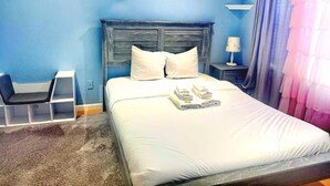 A hotel room with a large bed, two pillows, a nightstand with a lamp, and a window with curtains. - Spacious & Cozy Home 3BD 2BA Near SF (Daly City)