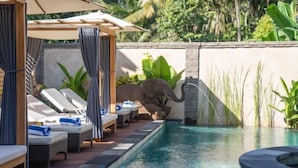 A pool area with lounge chairs and a decorative elephant statue. - The Compass Rose Ubud (Bali)