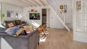 A spacious living room with a grey sofa, wooden coffee table, and a TV mounted on the wall. - "Tede" - 1km from the sea by Interhome (Ebeltoft)