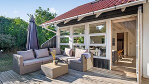 An outdoor deck with a sofa, cushions, and a table. - "Tede" - 1km from the sea by Interhome (Ebeltoft)