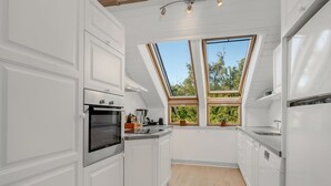 A modern kitchen with white cabinetry, a built-in oven, and a skylight. - "Tede" - 1km from the sea by Interhome (Ebeltoft)