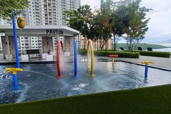 A water feature with multiple rings, a building labeled 'PAVILION,' and a view of a body of water. - Aesthetic 2BR @ Urban Suite (Infinite Pool & Gym) (George Town)