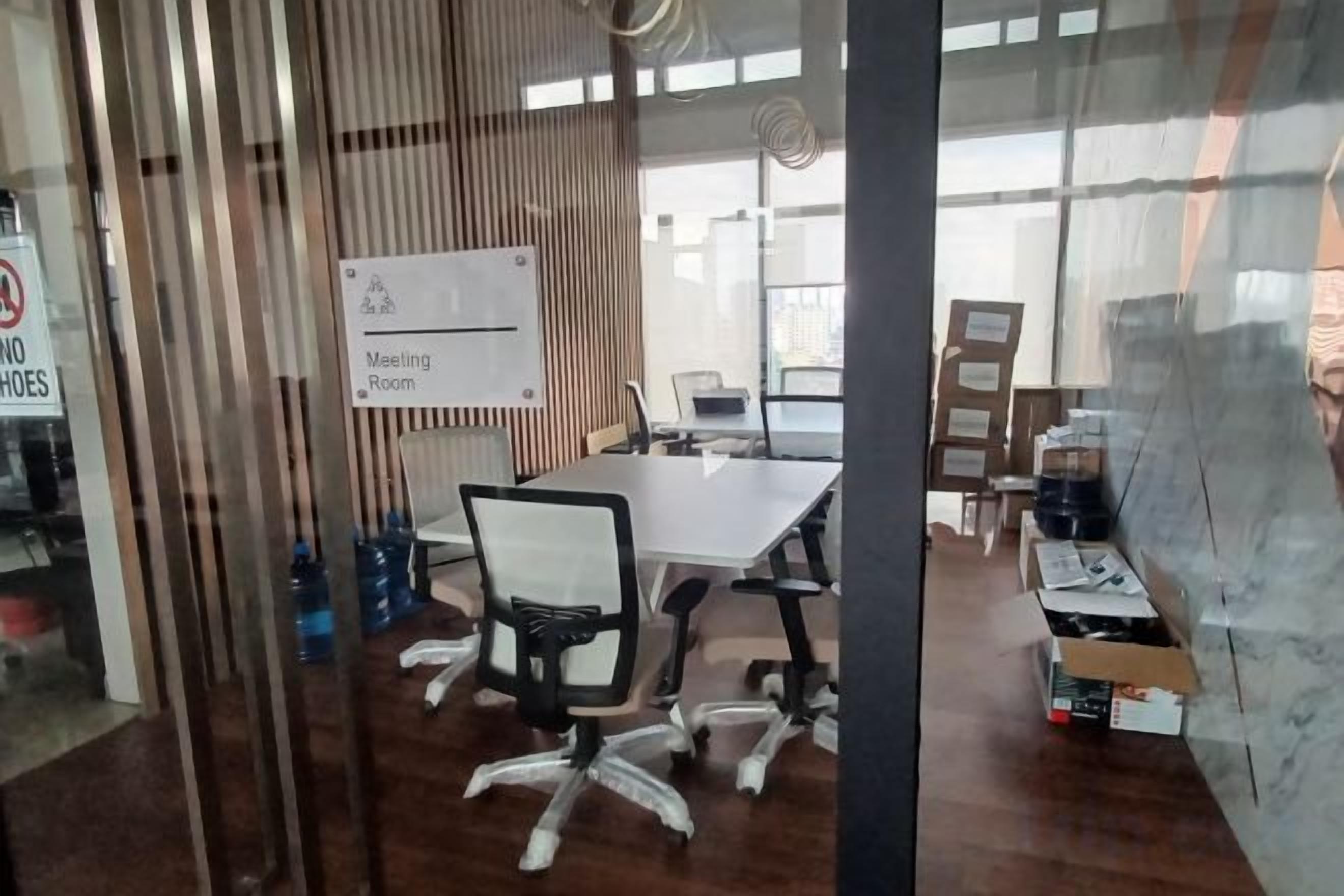 A meeting room with a whiteboard, a table, and office chairs.