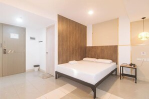 Een moderne slaapkamer met een houten hoofdbord, een nachtkastje en een bijzettafeltje.