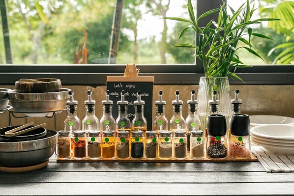 A kitchen counter with various spices and a sign that reads "Let's enjoy daily fresh vegetables."