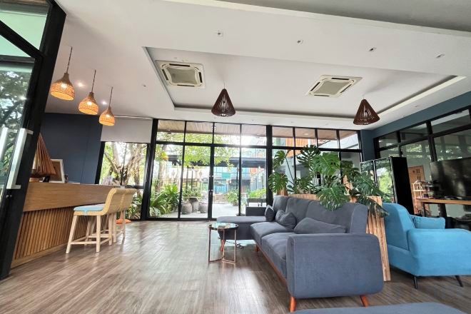 A modern interior with a reception desk, seating area, and large windows.