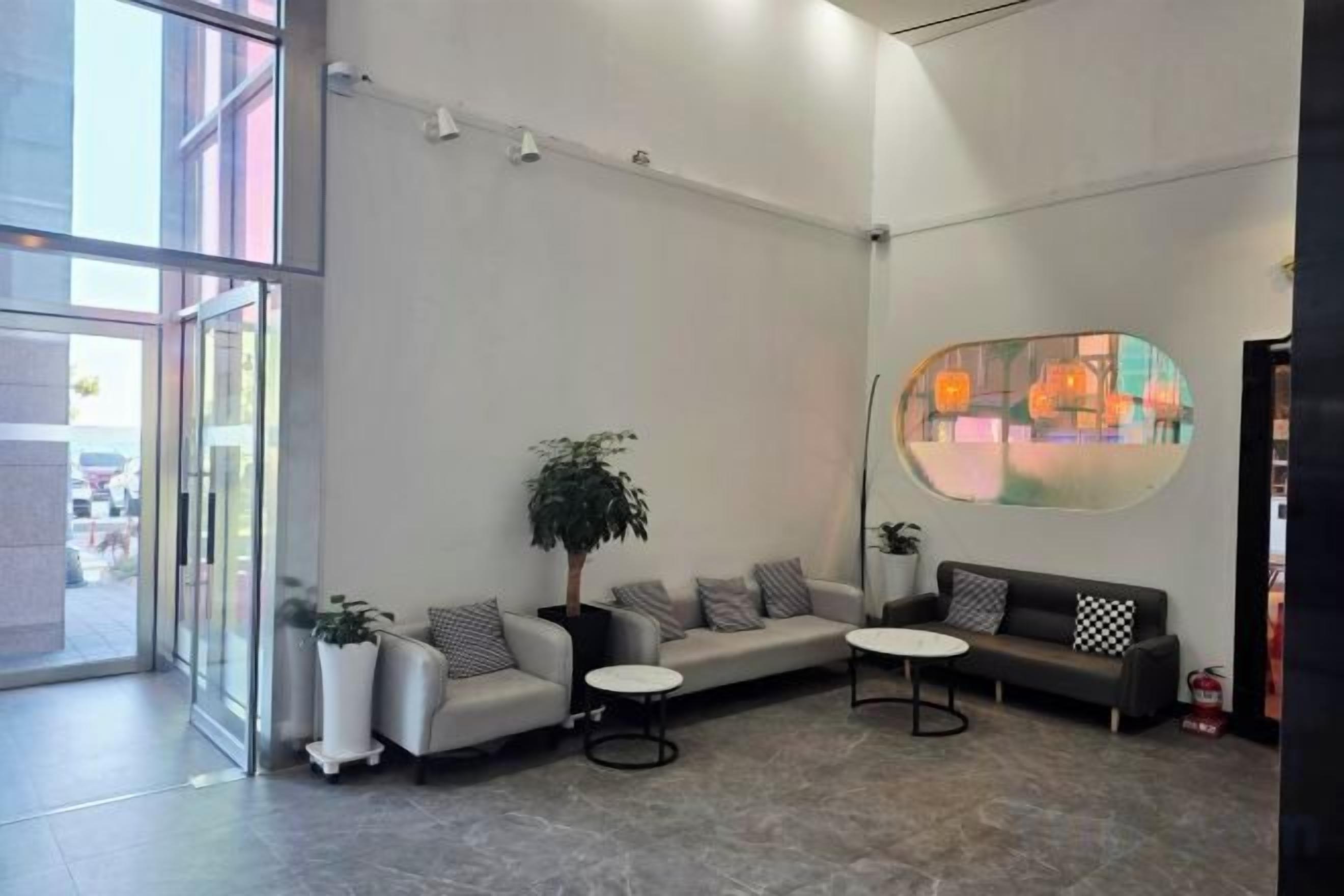 Un moderno vestíbulo con zona de estar, un ventanal grande y una obra de arte colgada en la pared.