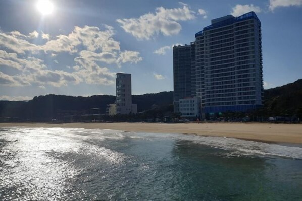 A beachfront hotel with a beach view, a tower, and a large building. - OceanStay E7 INN-The City jukdo (Yangyang)