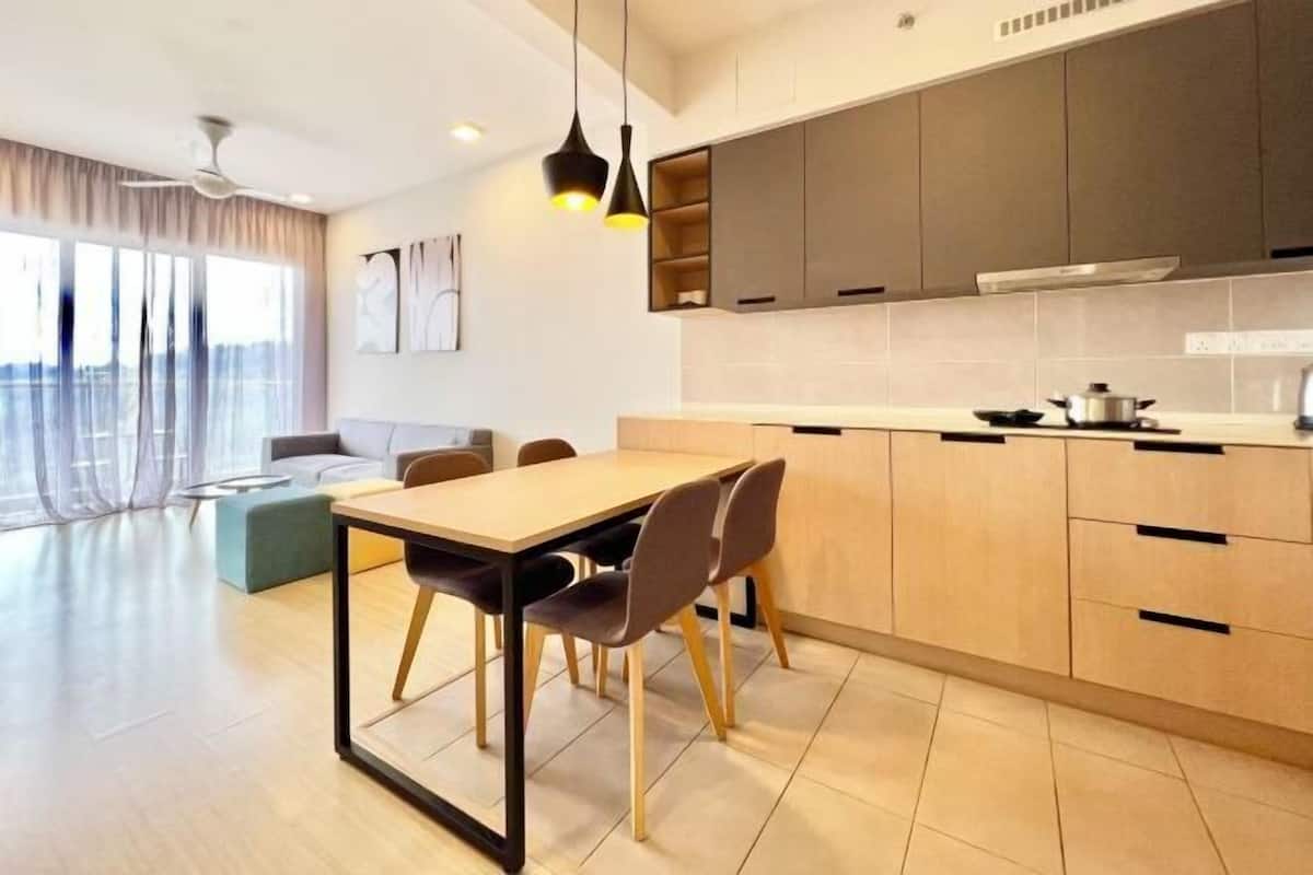 A modern kitchen with a dining area, large windows, and a ceiling fan.