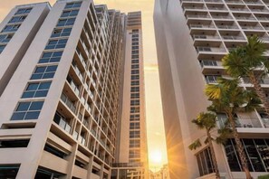 Un edificio de gran altura con varios pisos, ventanas amplias y un eje central para el ascensor.