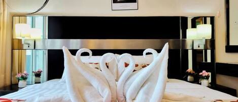 Habitación de hotel con una cama, cabecera, mesita de noche, lámpara y un cartel en la pared.