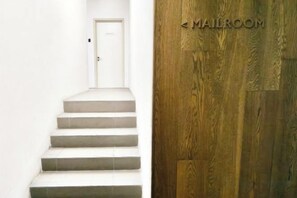 Una escalera que lleva a una puerta con un letrero que dice 'MAILROOM'.