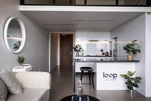 Una cucina moderna con isola centrale, un'area pranzo con divano e un soggiorno con tavolino da caffè.