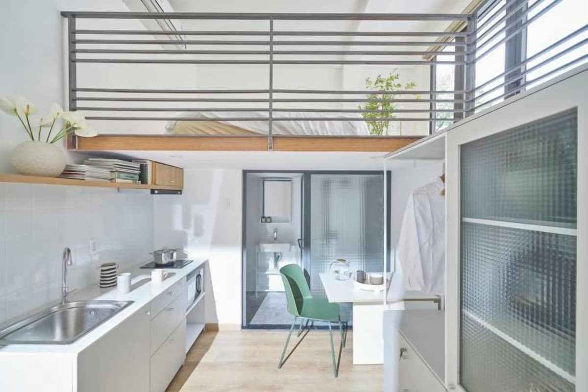 Een moderne keuken met een eethoek, een trap en uitzicht op buiten.