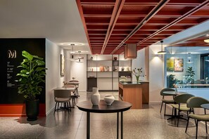 Un intérieur moderne comprenant un comptoir d’accueil, un espace détente et une vue sur l’extérieur.