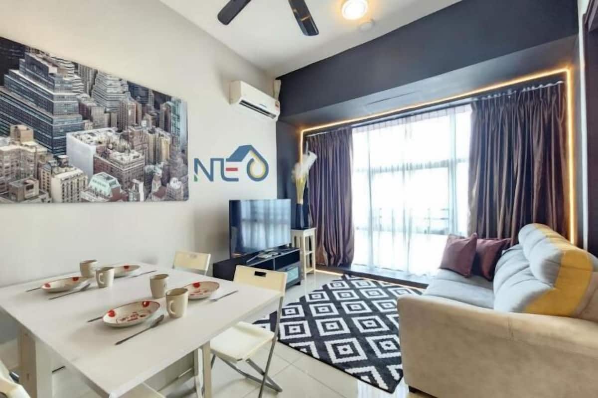 A modern living room with a dining area, a large cityscape artwork, and a sofa with cushions.