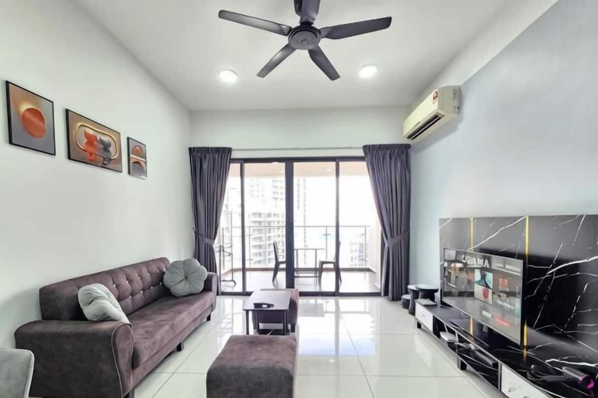 A modern living room with a sofa, a coffee table, a TV, and a ceiling fan.