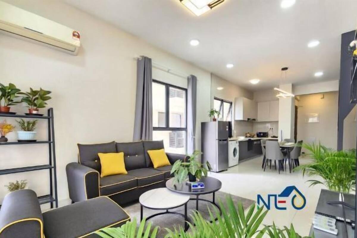 A modern living room with a sofa, coffee table, and plants.
