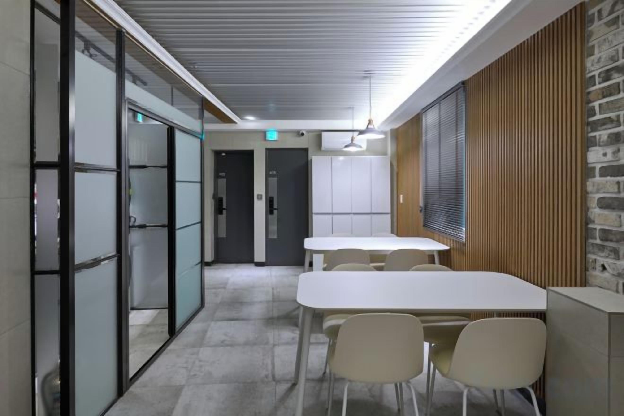 A conference room with a white table, chairs, and a wooden accent wall.