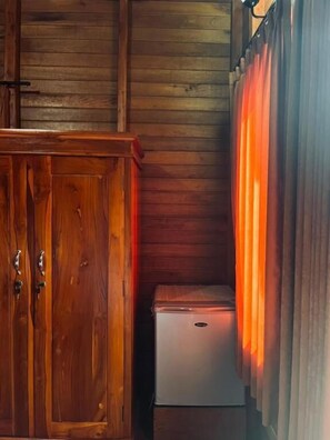 A wooden cabinet with a small refrigerator in a corner. - Nusa Dua Huts Pondok Gajah Para by EPS (Nusa Dua)