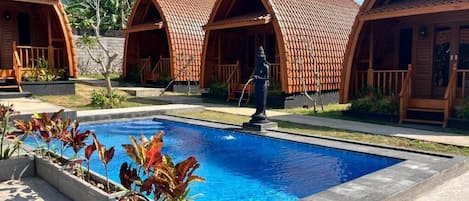 Una piscina al aire libre, tumbonas