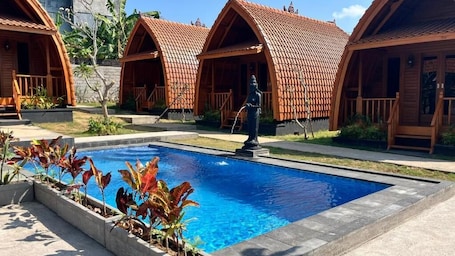 Una piscina al aire libre, sillones reclinables de piscina