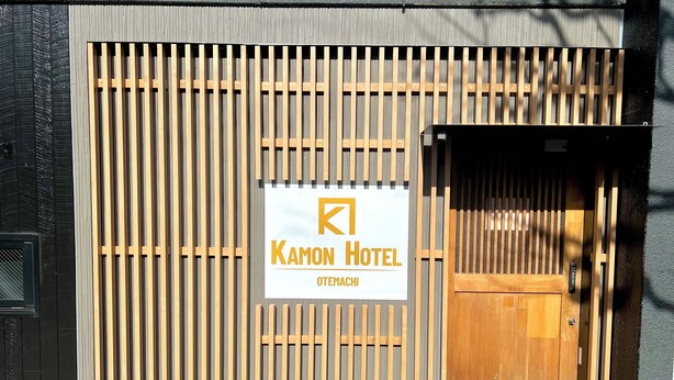 A hotel entrance with a wooden gate, a sign reading "Kamon Hotel Otemachi," and a door. - Otemachi Kamon Hotel - Caters to Men - Hostel (Tokyo)