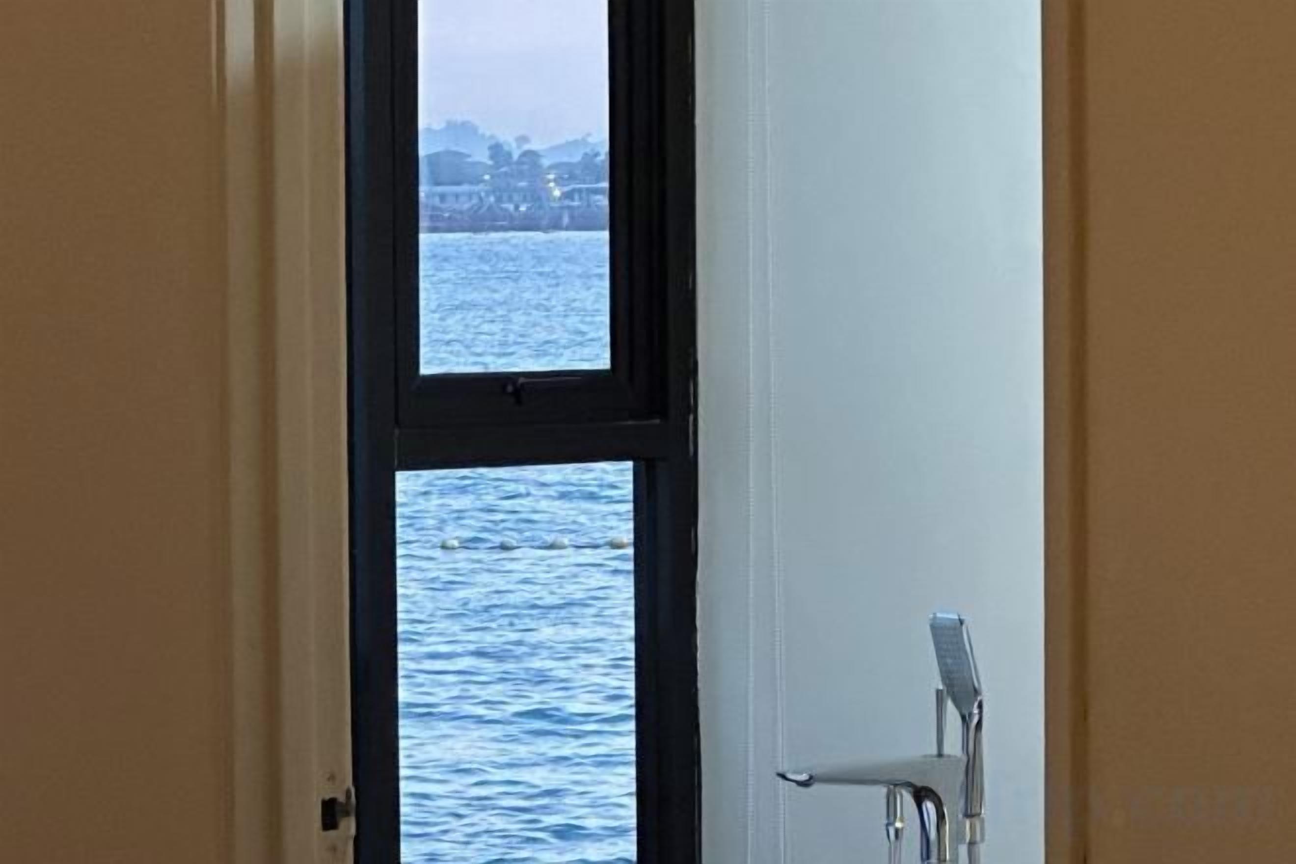 A room with a view of a body of water through a window.