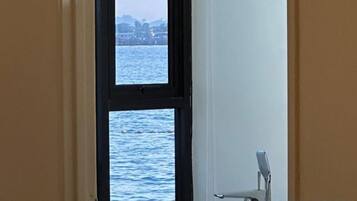 Une pièce avec vue sur une étendue d’eau, visible par une fenêtre.